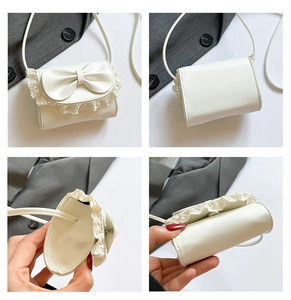 Detailed close-up of white mini shoulder bag with bow, lace trim and interior view