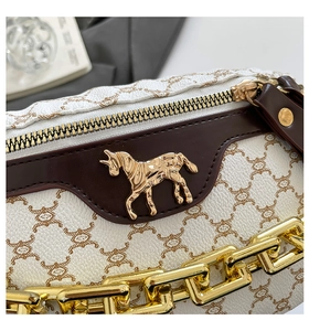 Detailed macro view of white pebble leather texture and golden unicorn metal emblem