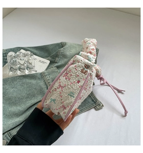 Detail of white pleated handbag with pink trim, cartoon bear prints and cloud handle