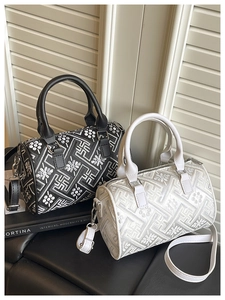 Detail of black and white bucket bags with ethnic geometric patterns and floral embroidery