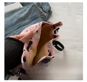 Détail du sac seau rose à imprimé nœuds montrant le fermoir aimanté et la doublure