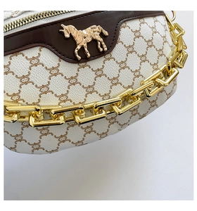Detail of vintage monogram canvas chest bag with gold horse buckle and chunky chain