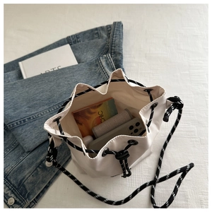 Top view of white drawstring bucket bag showing interior capacity with phone and accessories