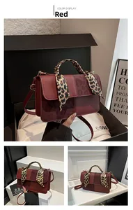 Macro detail of dark red crossbody bag with leopard print silk scarf on the handle