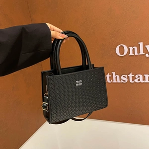 Chic black textured crossbody bag with double handles and metallic logo detailing