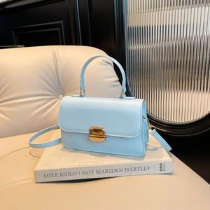 Minimalistische lichtblauwe leren handtas met gouden sluiting en elegant handvat