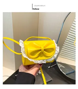 Detailed view of yellow handbag featuring a large bow and white lace trim edge