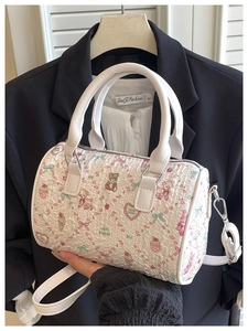 Detail of white Boston bag with cute cartoon bear prints and textured pleated surface