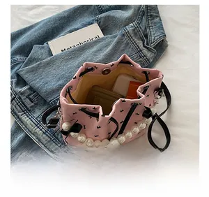 Détail de l'intérieur du sac seau rose montrant la capacité pour maquillage et mobile