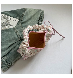 Detail of cute bear floral print puff bag with pink bow and yellow lining detail