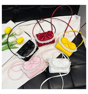 Flat lay of mini crossbody bags with bows and lace edges in five vibrant colors