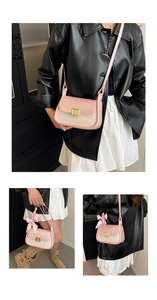 Detail of pink and beige leather crossbody bag with gold clasp and silk bow charm