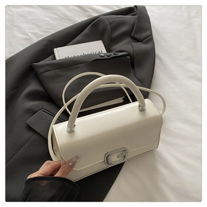 Detail of white leather shoulder bag with crystal G buckle on grey blazer backdrop