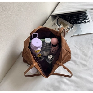 Top view of spacious brown tote bag interior showing water bottle and daily essentials
