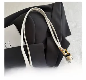 Dettaglio della borsa tote bianca coccodrillo con manico decorato da foulard di seta