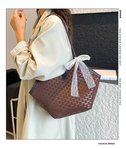 Détail du sac cabas monogramme avec nœud en dentelle blanche et fines anses en cuir