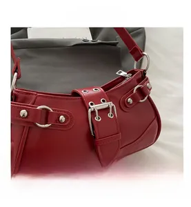 Detail view of red PU leather shoulder bag featuring silver metal rings and stud accents