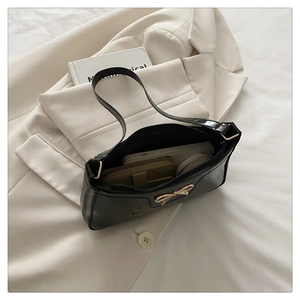 Interior view of black patent leather bow bag showing space for phone and wallet