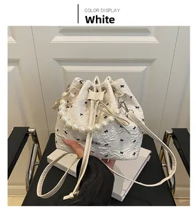 Sac seau blanc avec broderies nœuds papillon noirs et poignée en perles élégante