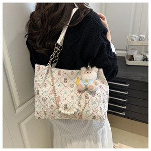 Detail of cute bear floral print tote bag with pearl gold chain strap and plush pendant
