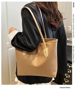 Detail of woven khaki tote bag featuring intricate cross-braided texture and long straps