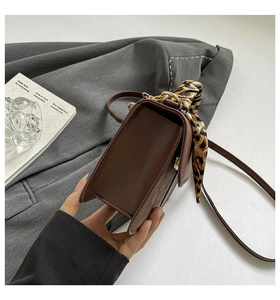 Brown PU leather crossbody bag featuring a leopard print scarf handle and gold hardware detail