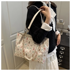 Close-up of jacquard tote bag with cute bear patterns and elegant pearl chain detail