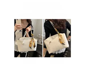 Détail d'un sac cabas blanc à motif croco avec foulard décoratif et double mode de porté