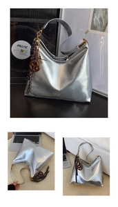 Détail du sac bandoulière argenté métallisé avec pendentif nœud et texte de mode