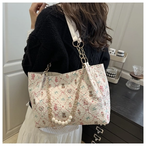 Detail of floral tote bag with large pearl handle and gold chain strap decoration