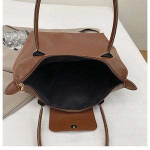 Internal view of brown leather tote bag with gold zipper and magnetic front pocket