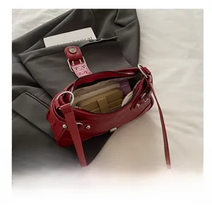 Top-down view showing interior storage of this red leather shoulder bag with essentials
