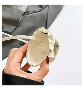 Close-up of white crossbody bag featuring delicate lace trim and PU leather details