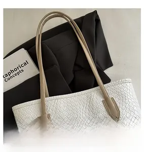 Detail of white woven tote bag with slim khaki handles on a stylish office blazer