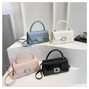 Detail of multi-color patent leather handbags featuring a sparkling rhinestone G buckle