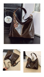 Détail d'un sac hobo brillant marron foncé avec finitions dorées et pendentifs