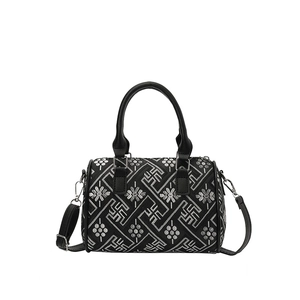 Classic black bucket bag with white geometric floral embroidery and silver hardware detailing