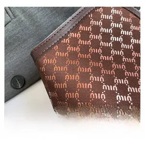 Détail macro du sac cabas à monogramme marron avec surpiqûres et finitions en cuir