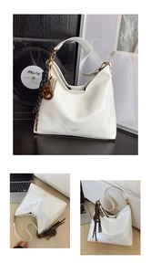 Détail du sac hobo en cuir verni blanc avec lettrage et pendentif noeud tressé