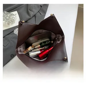 Vue intérieure du sac seau en cuir montrant un espace spacieux pour maquillage et téléphone