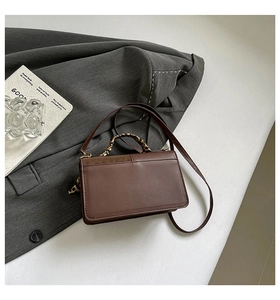 Close-up of brown leather handbag with leopard print scarf wrap on handle and shoulder strap