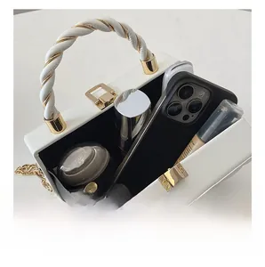 Internal storage view of white wave pattern evening bag with phone and perfume