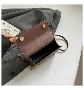 Detail showing the spacious interior and dual magnetic closures of the brown leather bag