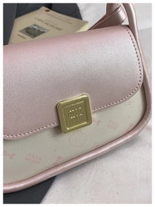 Detailed close-up of premium bow leather crossbody bag with golden metal buckle clasp