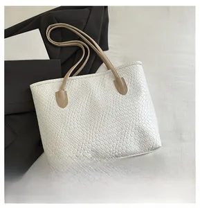 Detail of white woven tote bag texture with tan shoulder straps on minimalist background