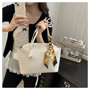 Détail d'un sac cabas blanc à motif crocodile avec foulard décoratif en soie en selfie miroir