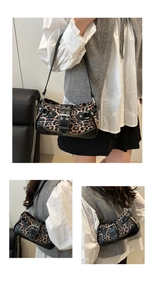 Detail of leopard print hobo bag showing faux leather straps and silver metal buckles