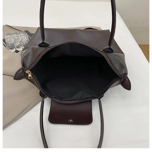 Detailed top view of a brown tote bag interior showing the zipper and golden hardware
