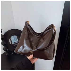 Détail du sac hobo marron foncé brillant avec logo doré Fashion Bags et crochet en métal