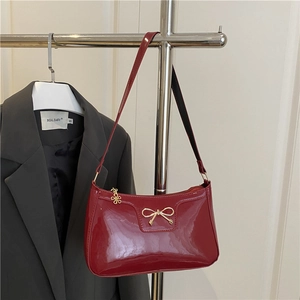 Borsa baguette in vernice rossa lucida con fiocco dorato e ciondolo a fiore